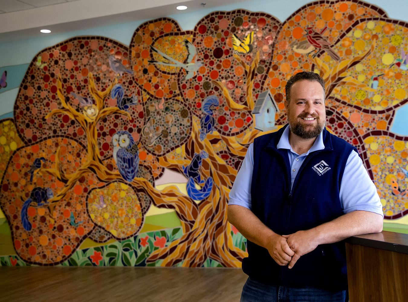 Artist Nick Bayer in front of mosaic