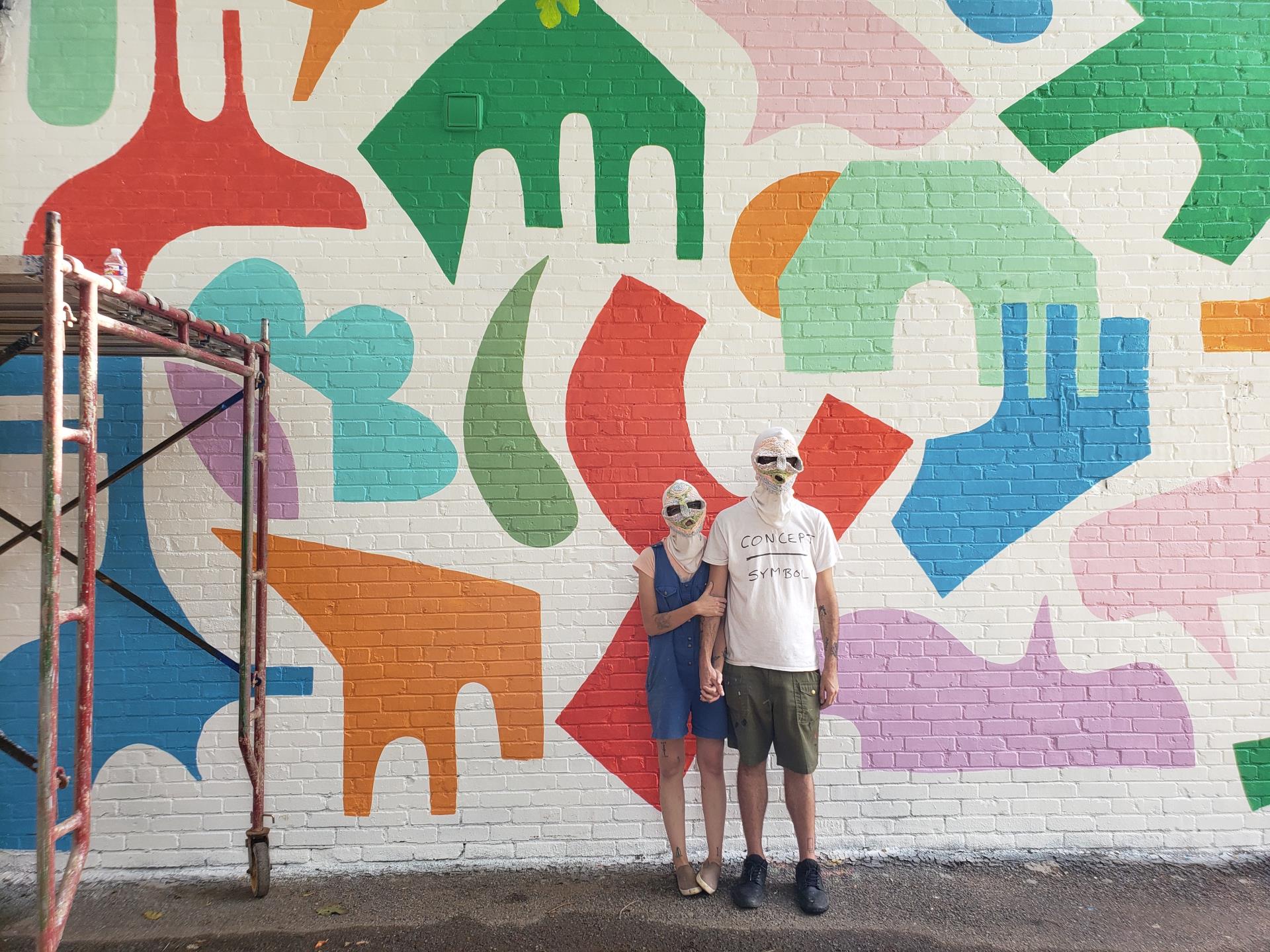 artist holey kids standing in front of mural