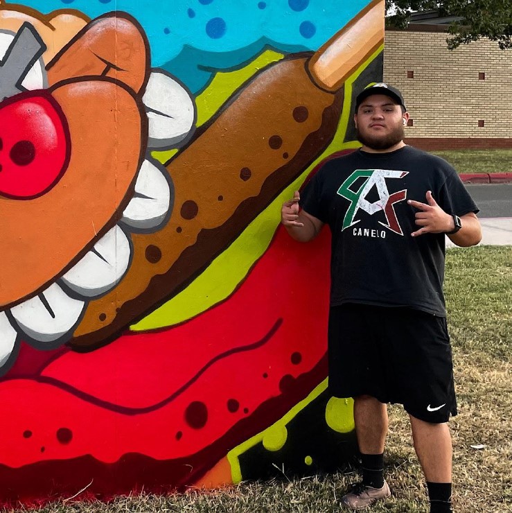 Artist Jose Scott next to mural