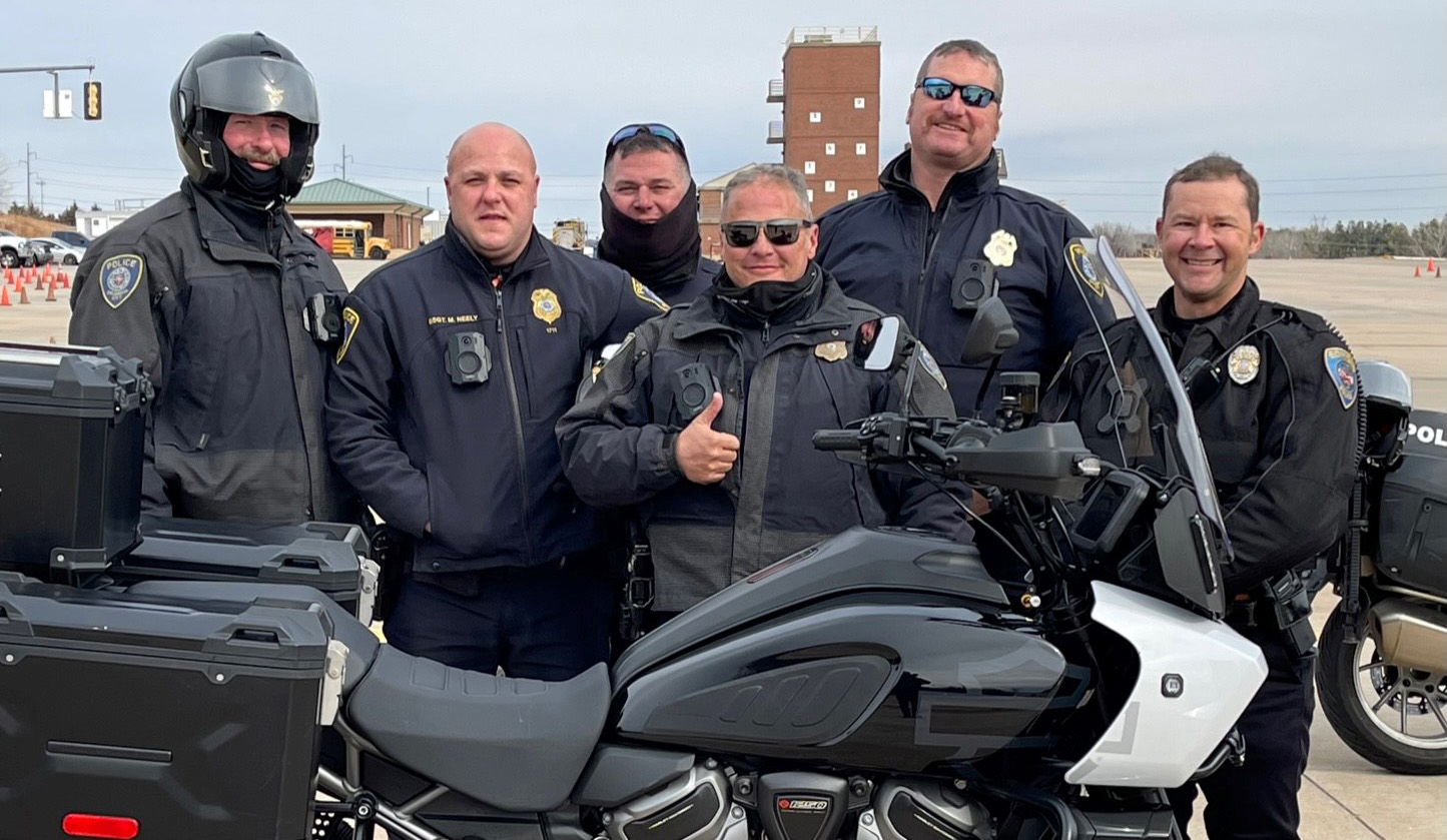 police officers in group behind motorcycle