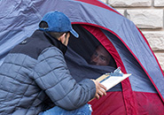 person in jacket talking to someone in a tent