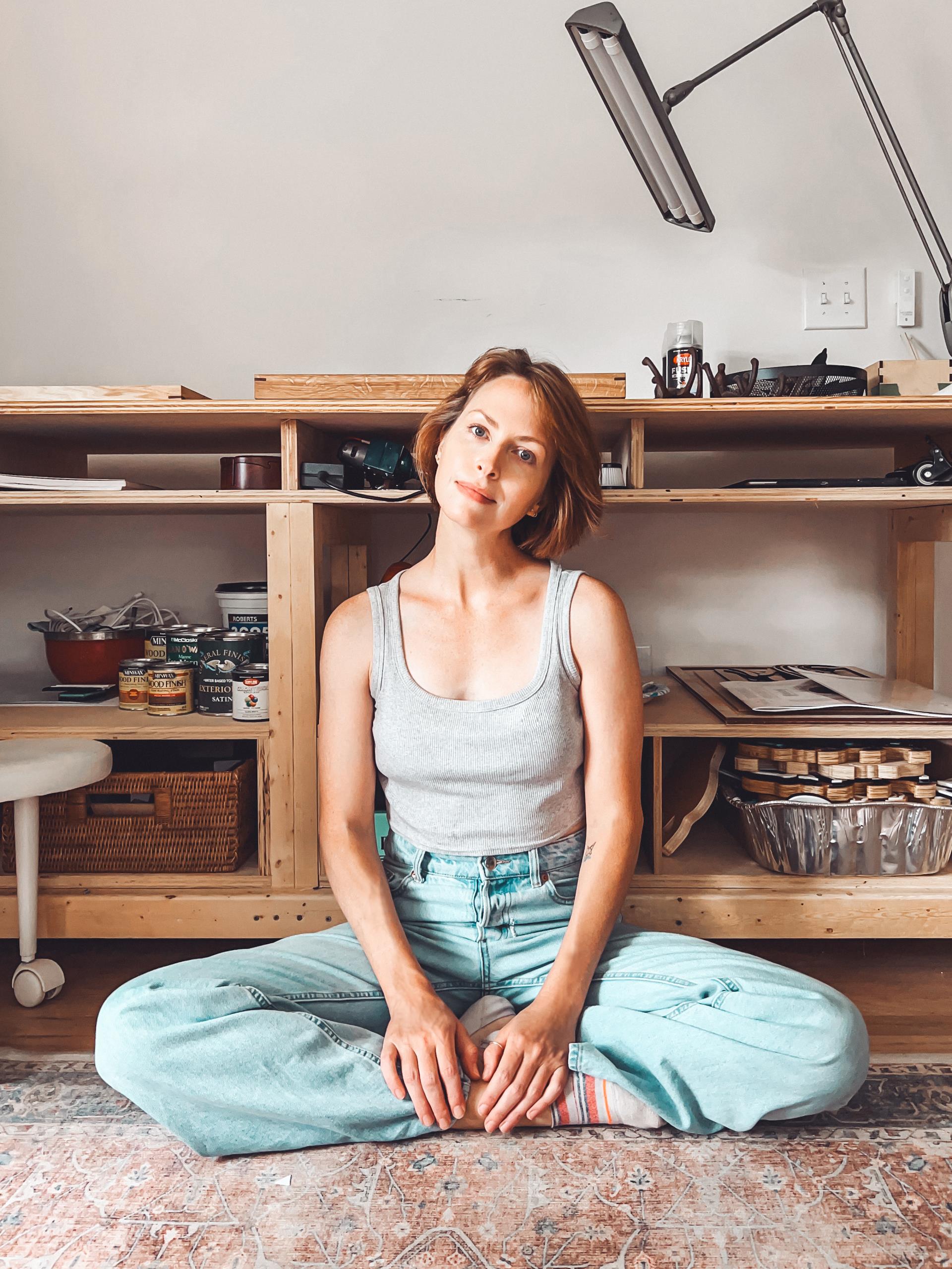 Andrea St. Clair sitting with legs crossed on the floor