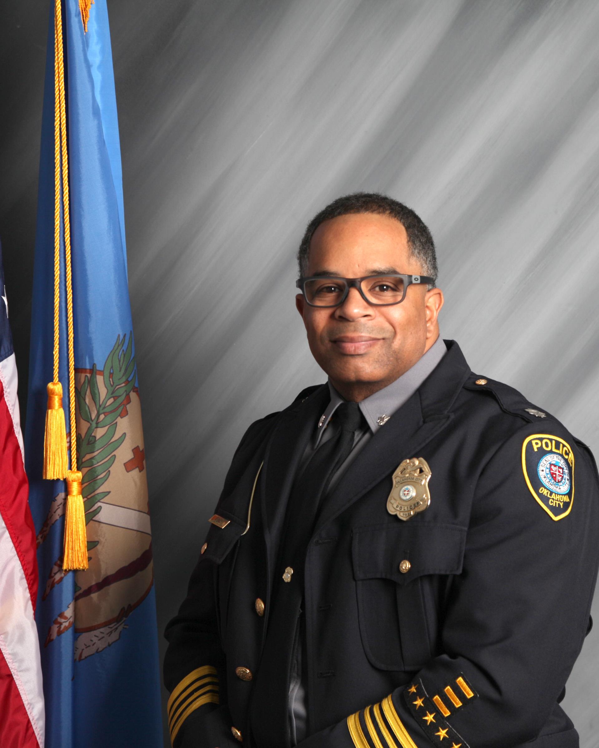 police chief sitting next to flag